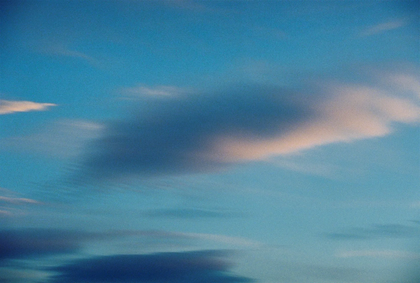 Image représentant le ciel bleu zébré de nuages gris et blanc.
